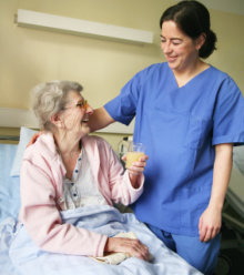 certified nurse assisting the old woman